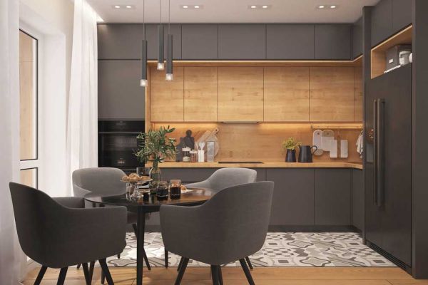 A stylish, modern kitchen featuring charcoal-gray and light wood cabinetry, a small dining area with gray upholstered chairs, and warm under-cabinet lighting.
